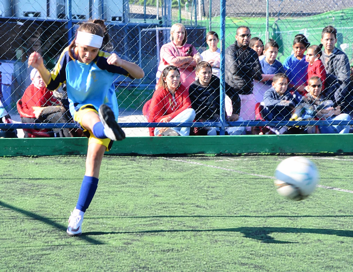 Lara chutando a bola durante uma partida de futebol