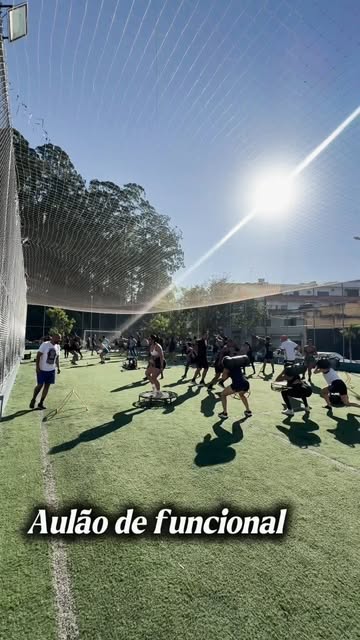 Participantes realizando exercícios funcionais sob orientação profissional na quadra